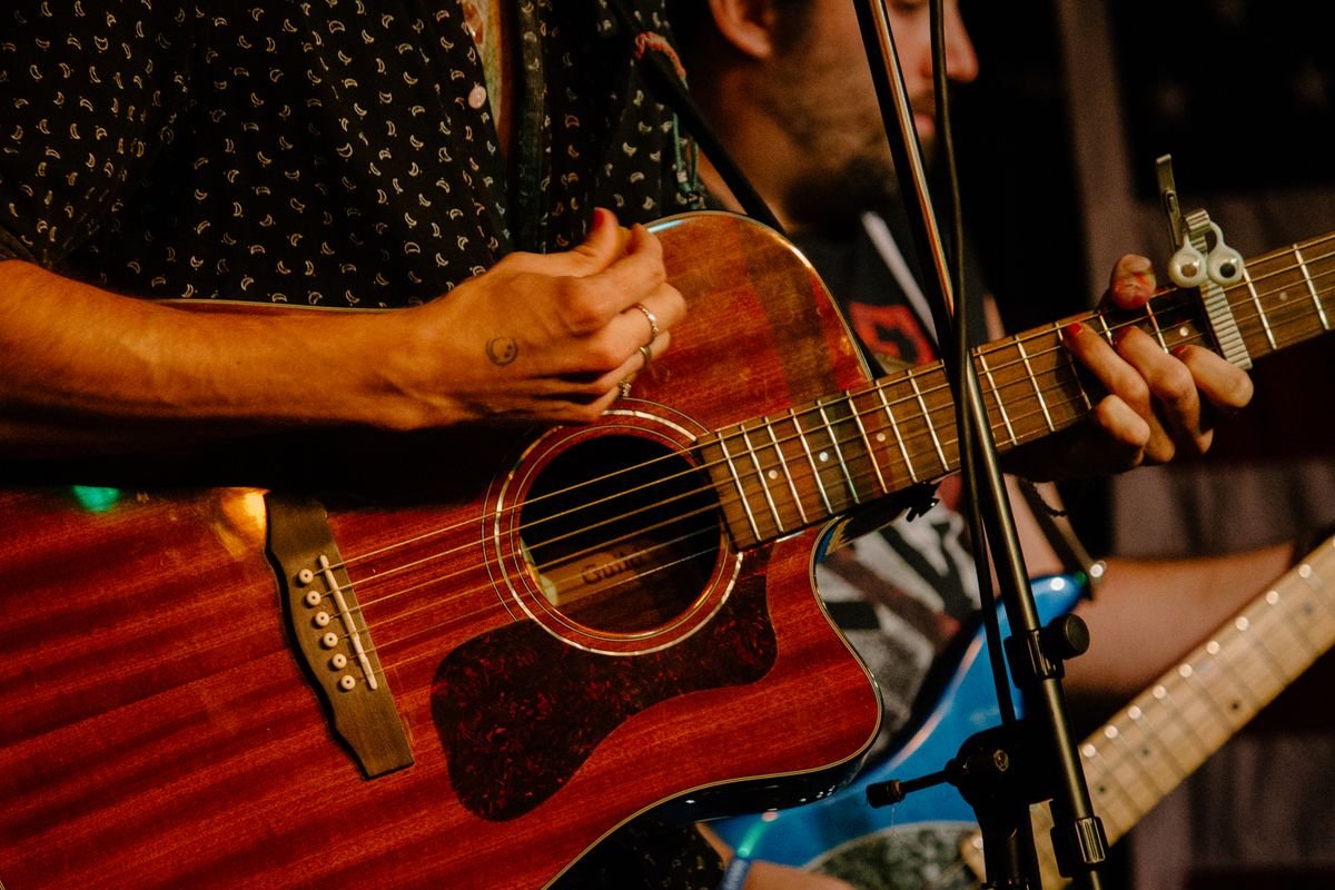 Musicians playing acoustic guitars at a live pub session