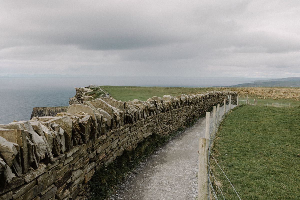 The official cliff path at the Cliffs of Moher with stone wall, the Atlantic stretching out to the left