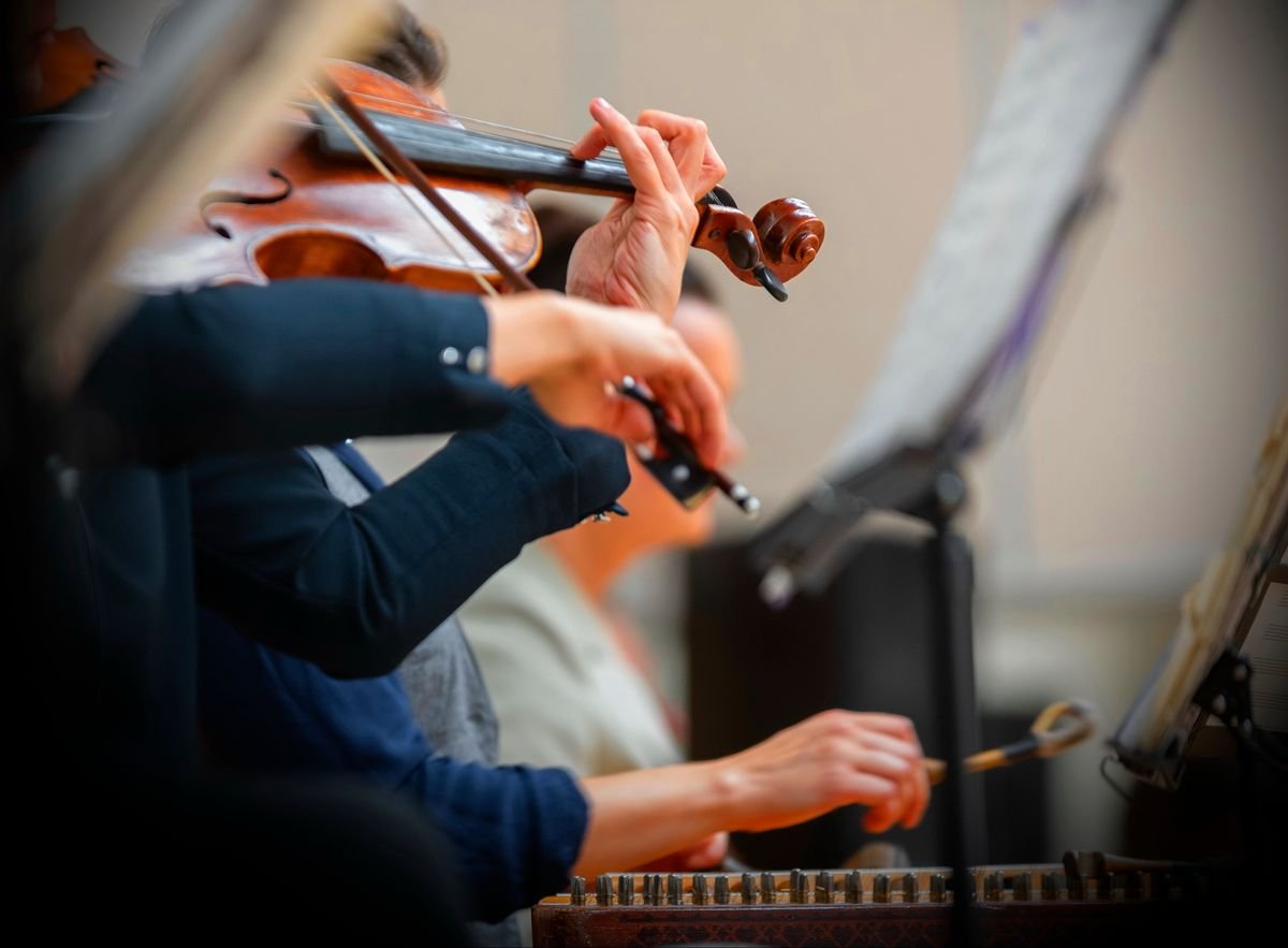 Close-up of a fiddle being played mid-session with a hammered dulcimer alongside it