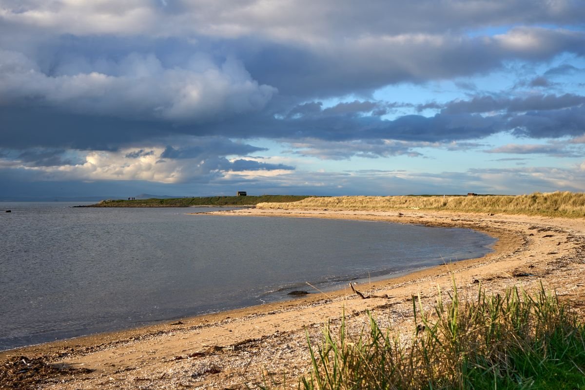 Curving sandy beach backed by grassy dunes at Brittas Bay on the Wicklow coast.