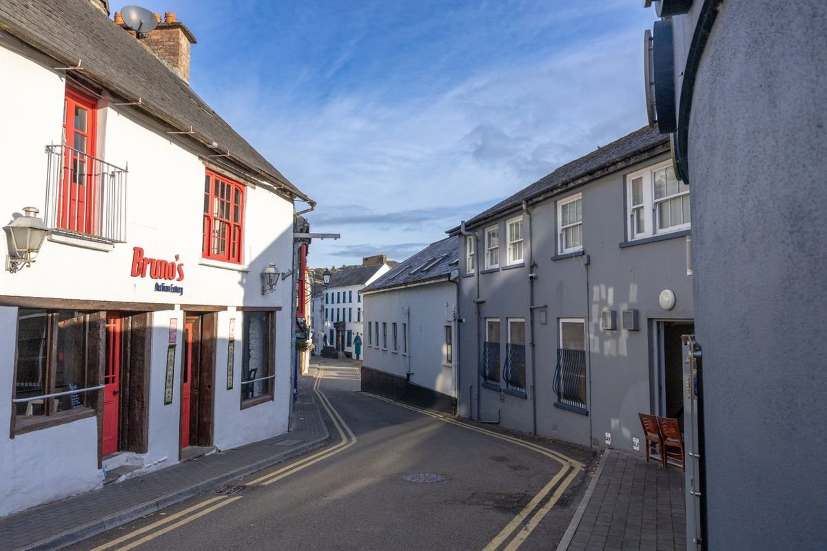 Painted shopfronts on a narrow street in Kinsale, County Cork