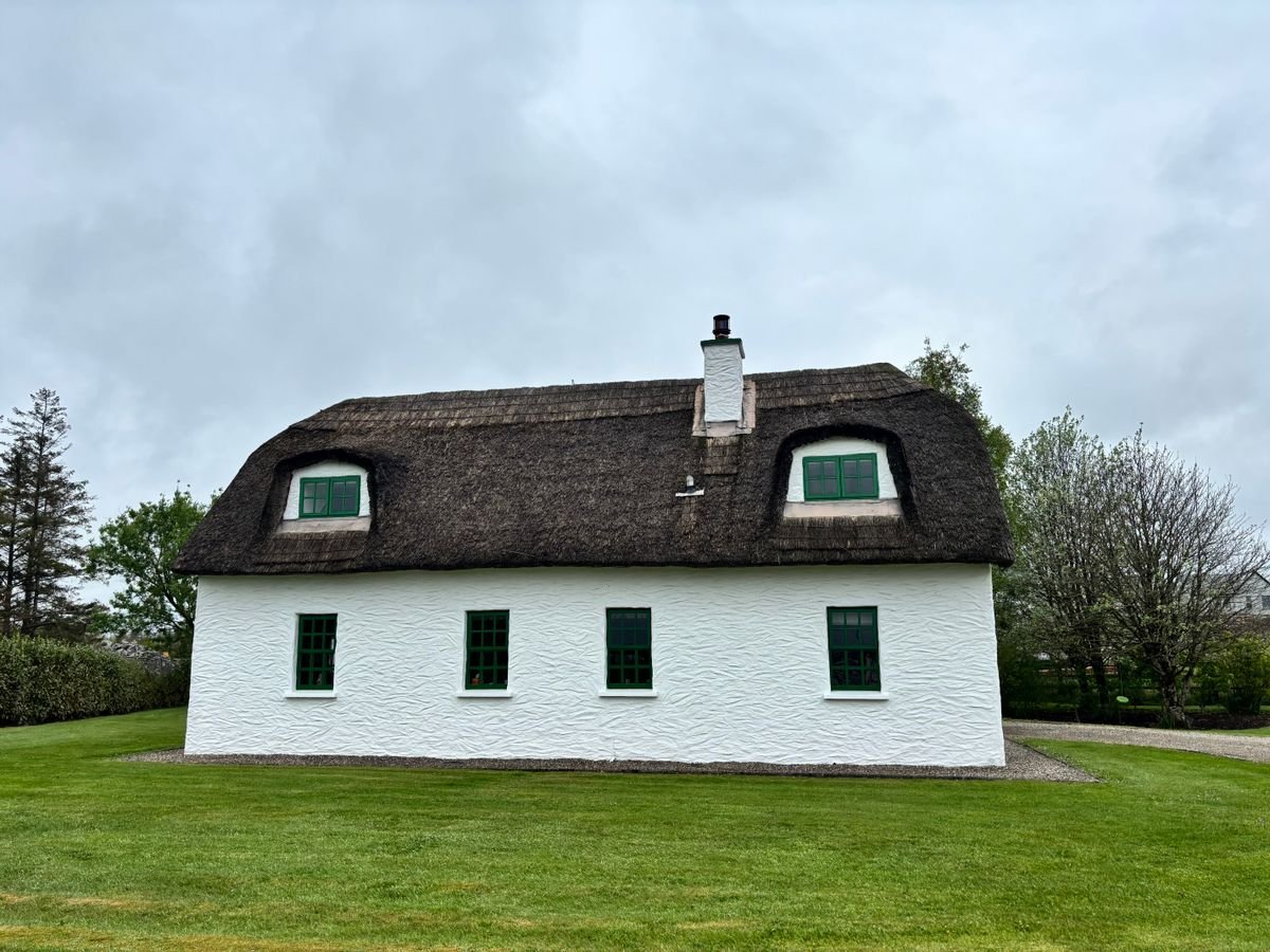 White thatched cottage with green windows in Connemara