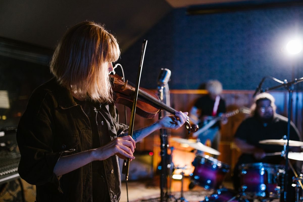 Fiddle player performing a trad session in a dim pub