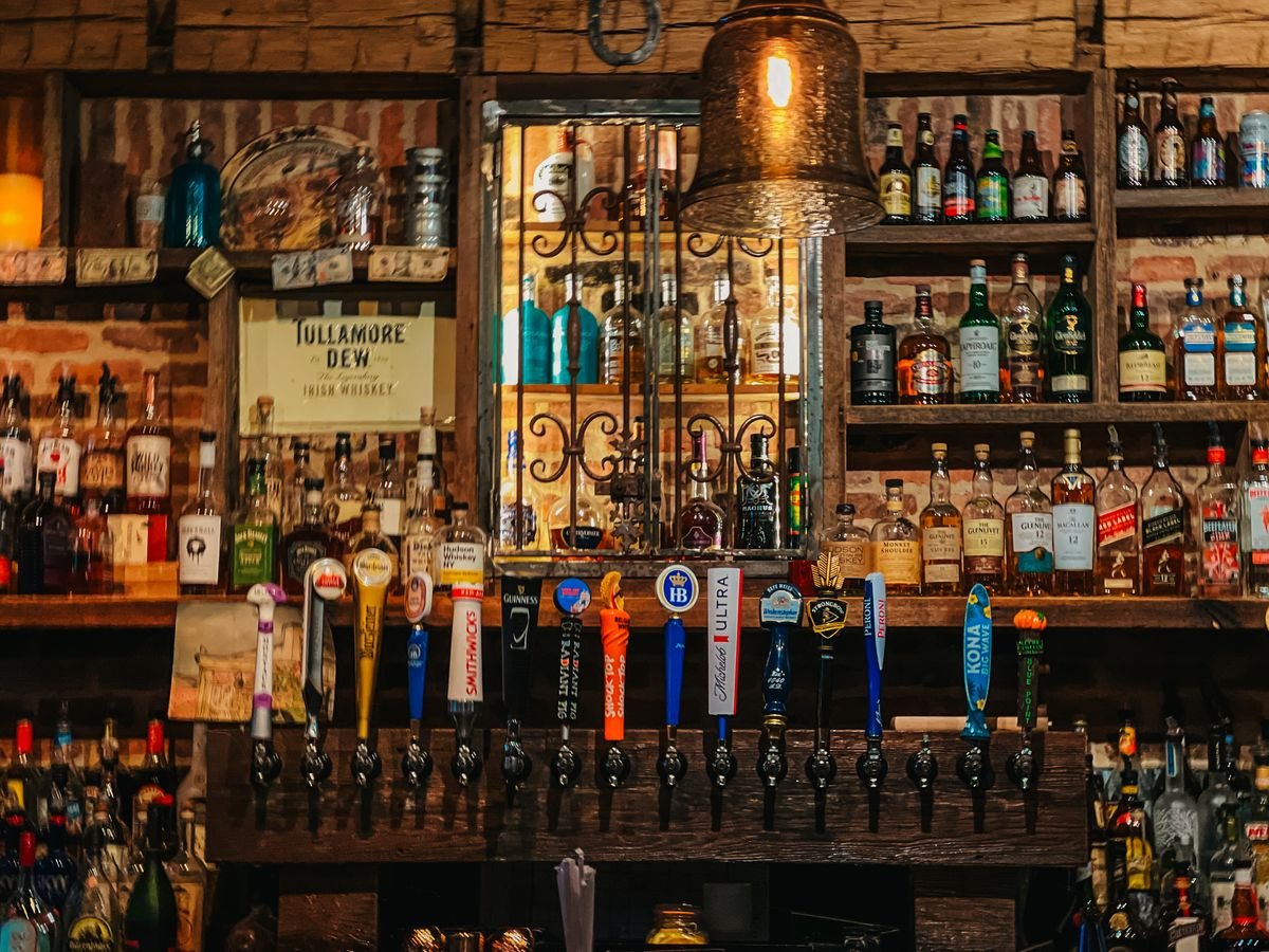 Warm Irish pub interior with whiskey bottles and beer taps