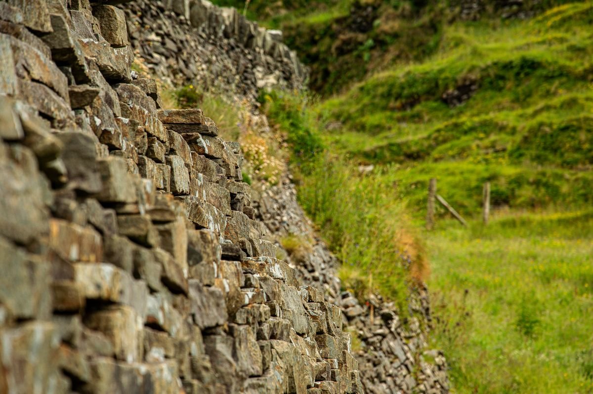 A dry-stone wall beside a rough grassy trail in Ireland
