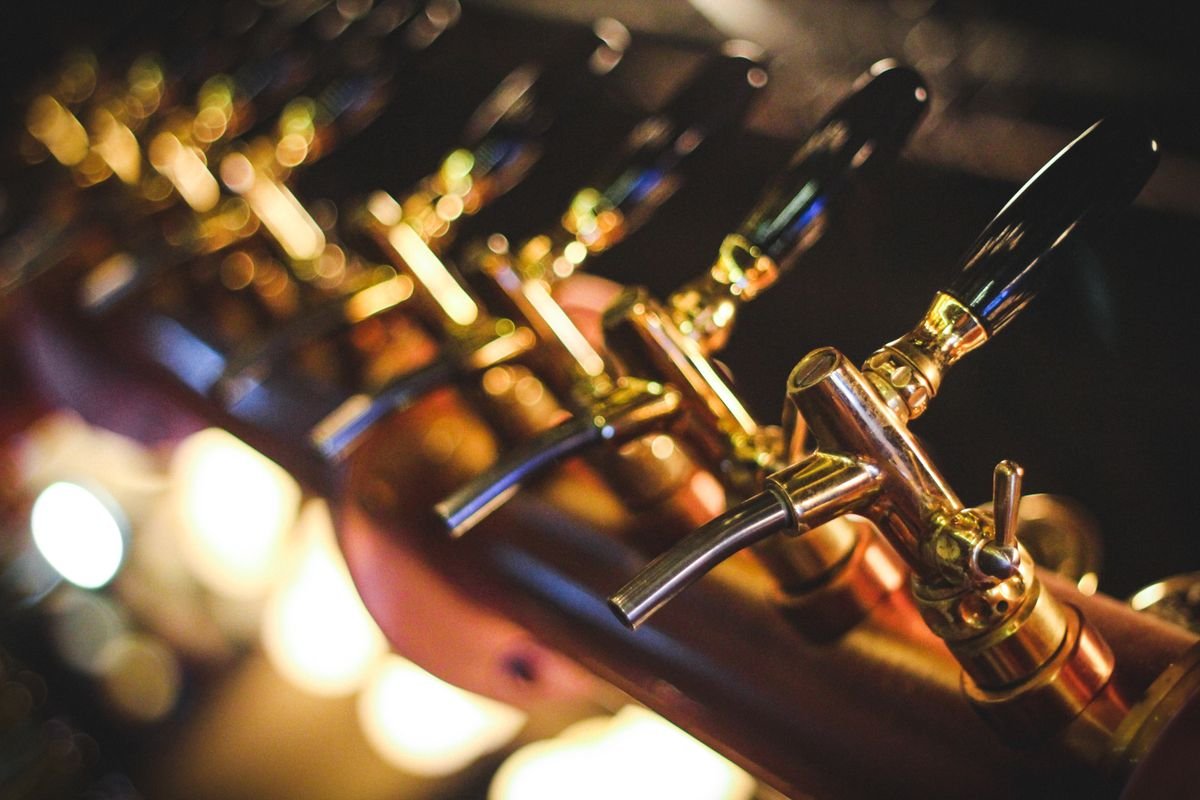Close-up of polished brass beer taps on a traditional pub bar