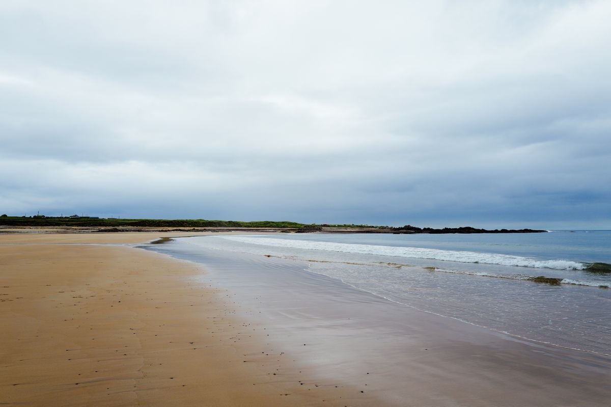 Quiet empty Irish beach under soft overcast light with gentle surf
