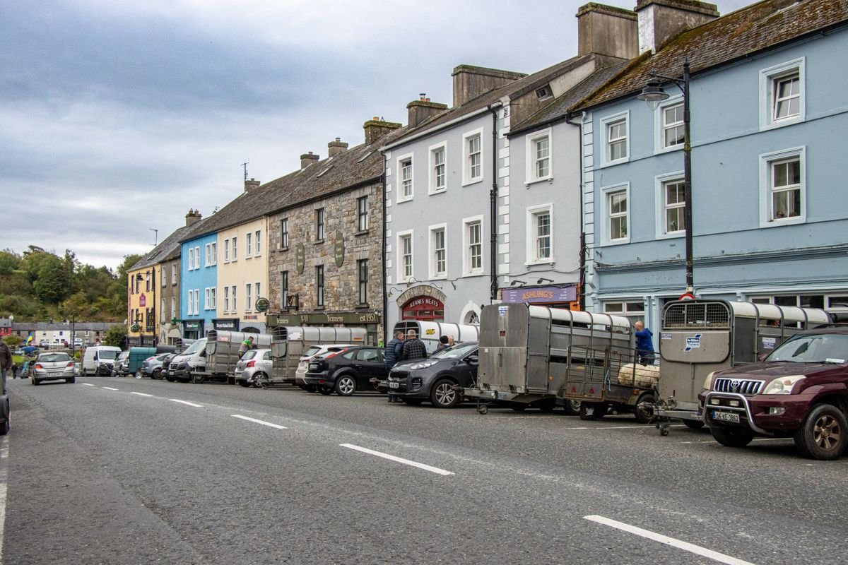 Colourful Irish town high street with terraced townhouses and parked cars
