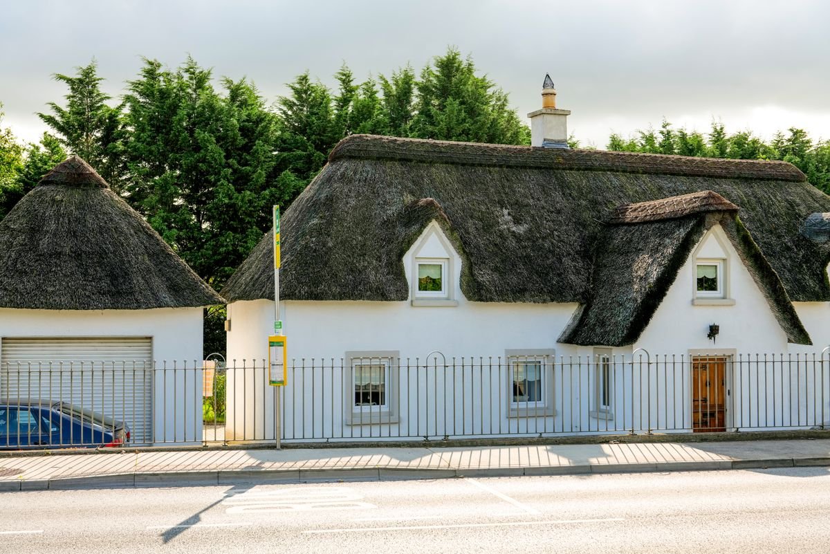 Traditional white thatched cottage in the Irish countryside
