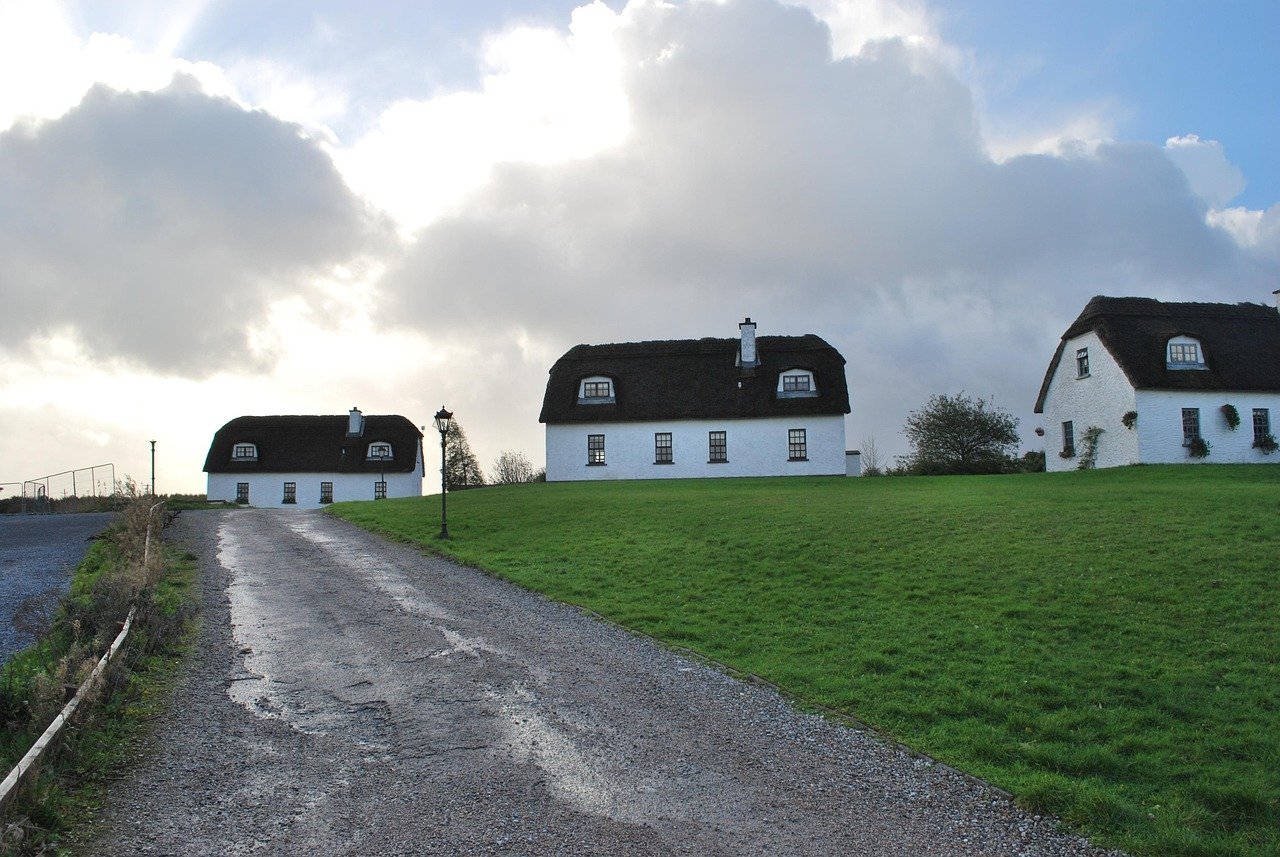 A row of thatched self-catering holiday cottages on a green Irish hill