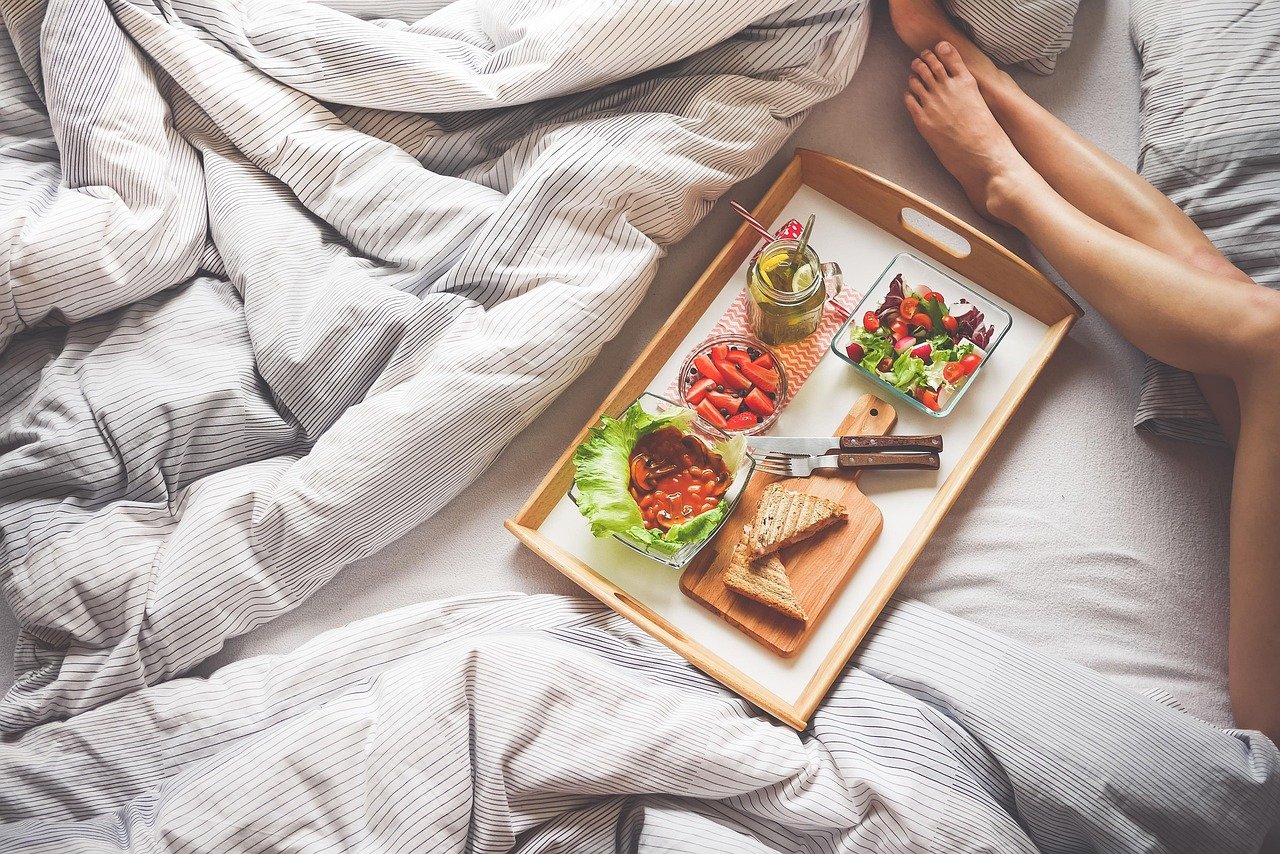 A breakfast tray on a bed, the case for two nights per base