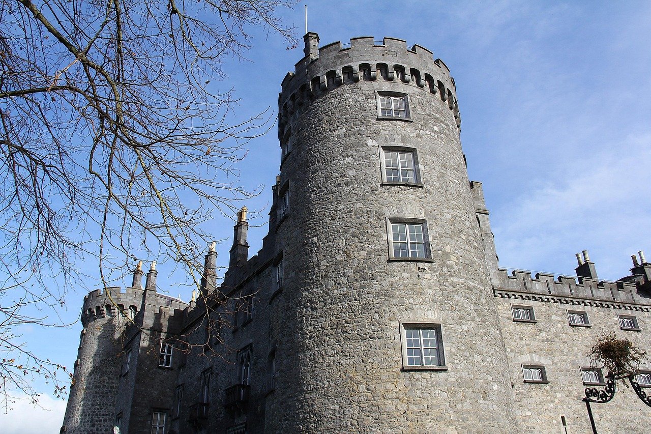 The round tower of Kilkenny Castle against a blue sky