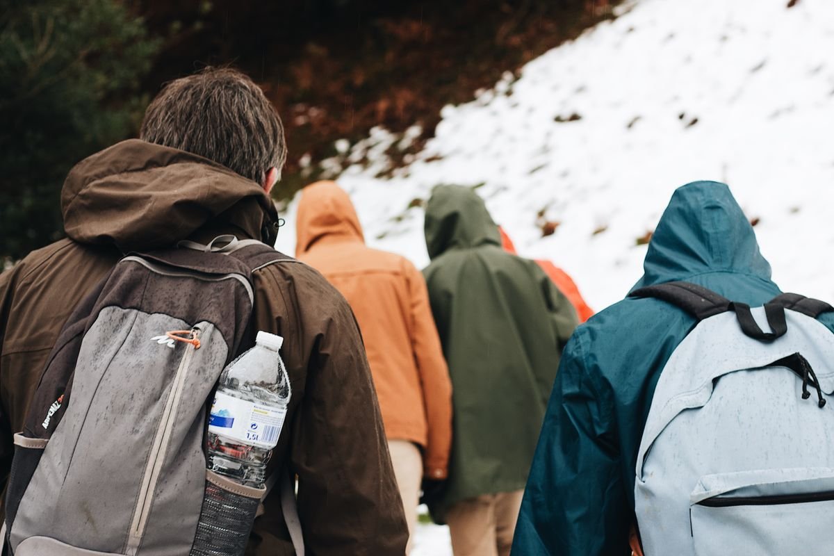 Walkers in waterproof jackets with backpacks on a coastal hike