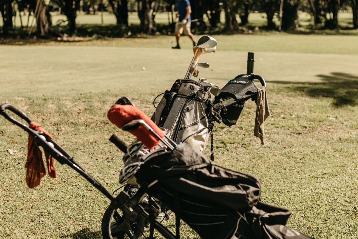 A golf bag on a push cart on the course
