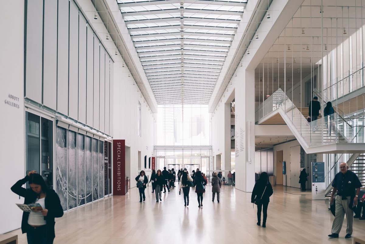 Visitors walking through a bright museum gallery
