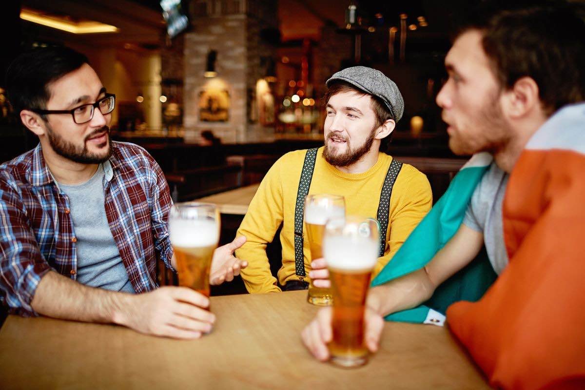 Friends drinking pints in a pub