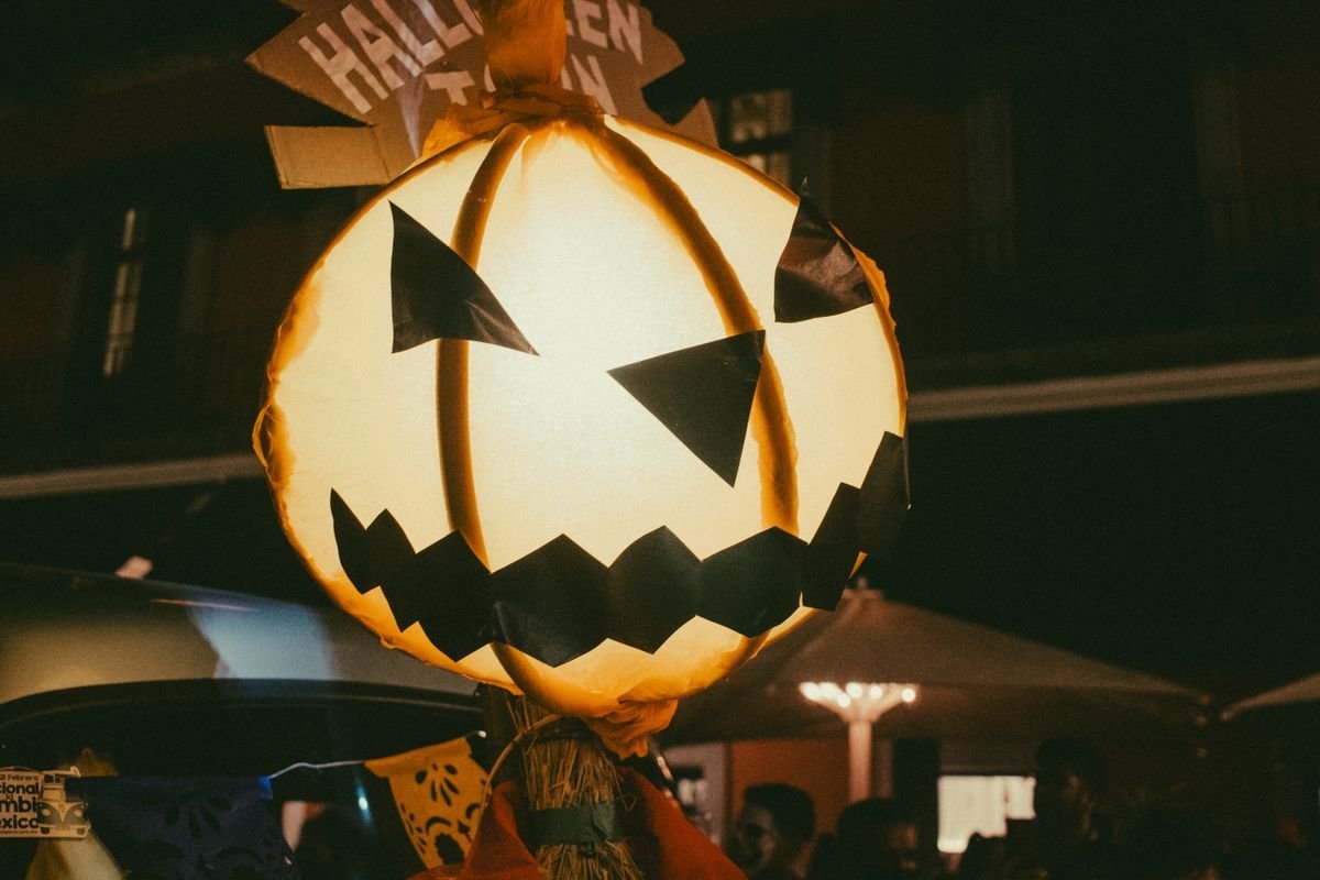 Glowing Halloween lantern held up in a Derry night crowd
