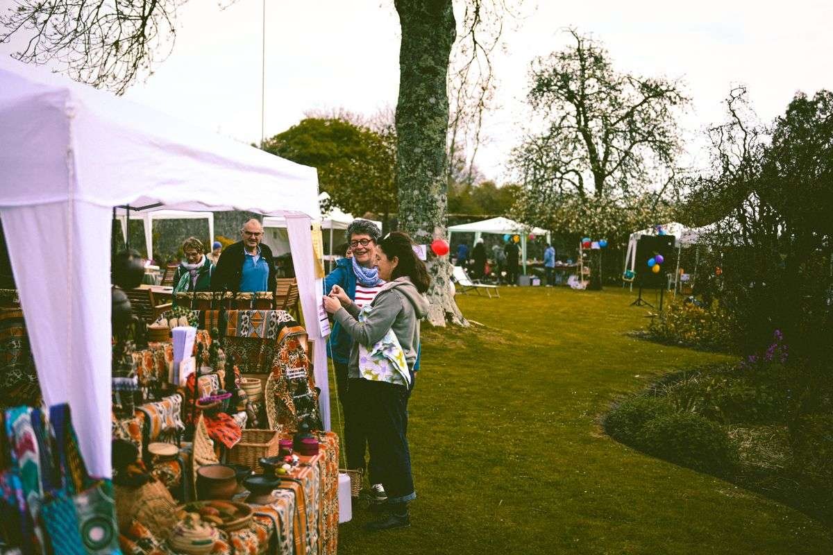Handmade goods on outdoor craft market stalls under white tents