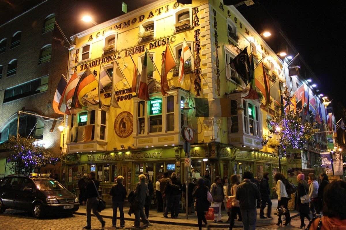 Crowd outside a Dublin pub lit up at night