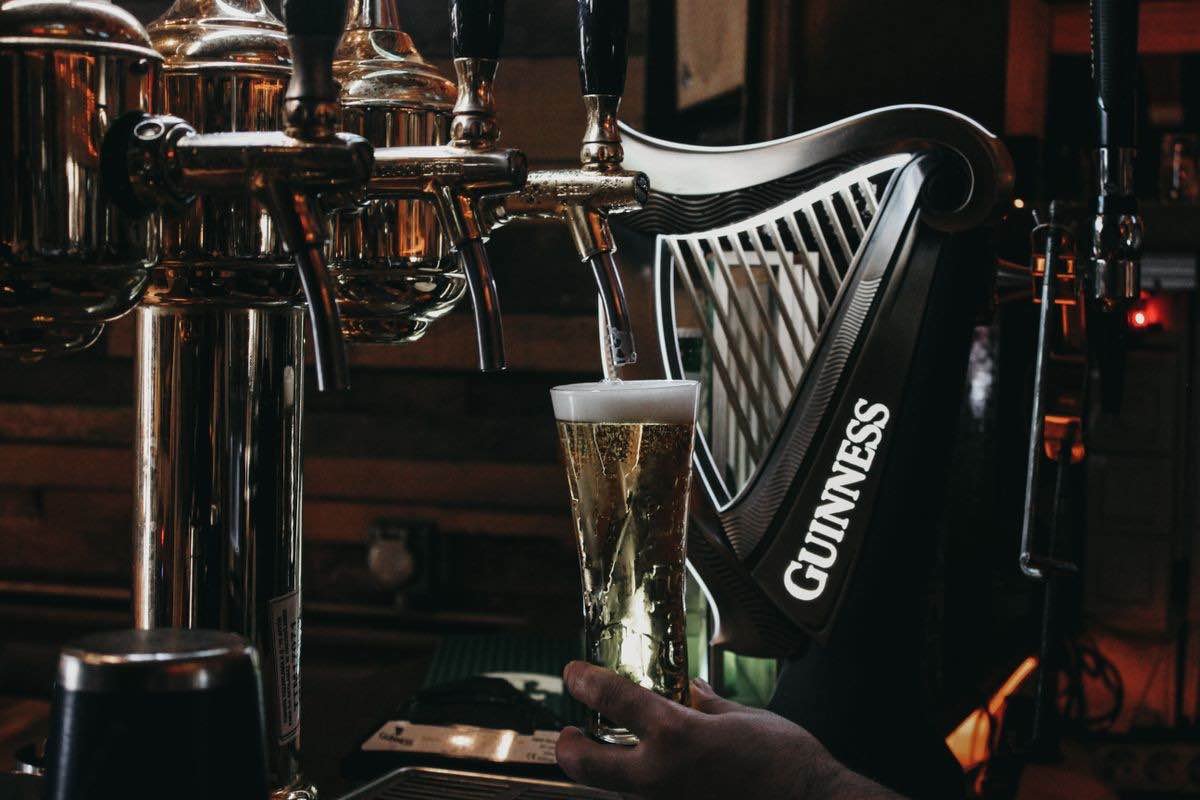 Pint on a stool beside a guitar in a pub