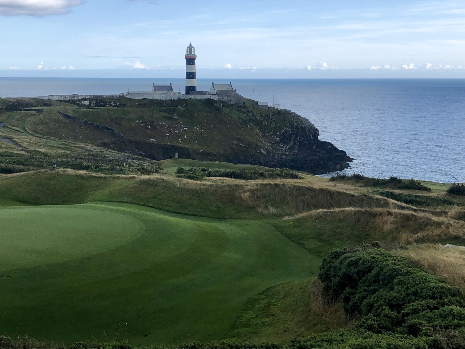 Old Head of Kinsale lighthouse and clifftop golf green above the sea
