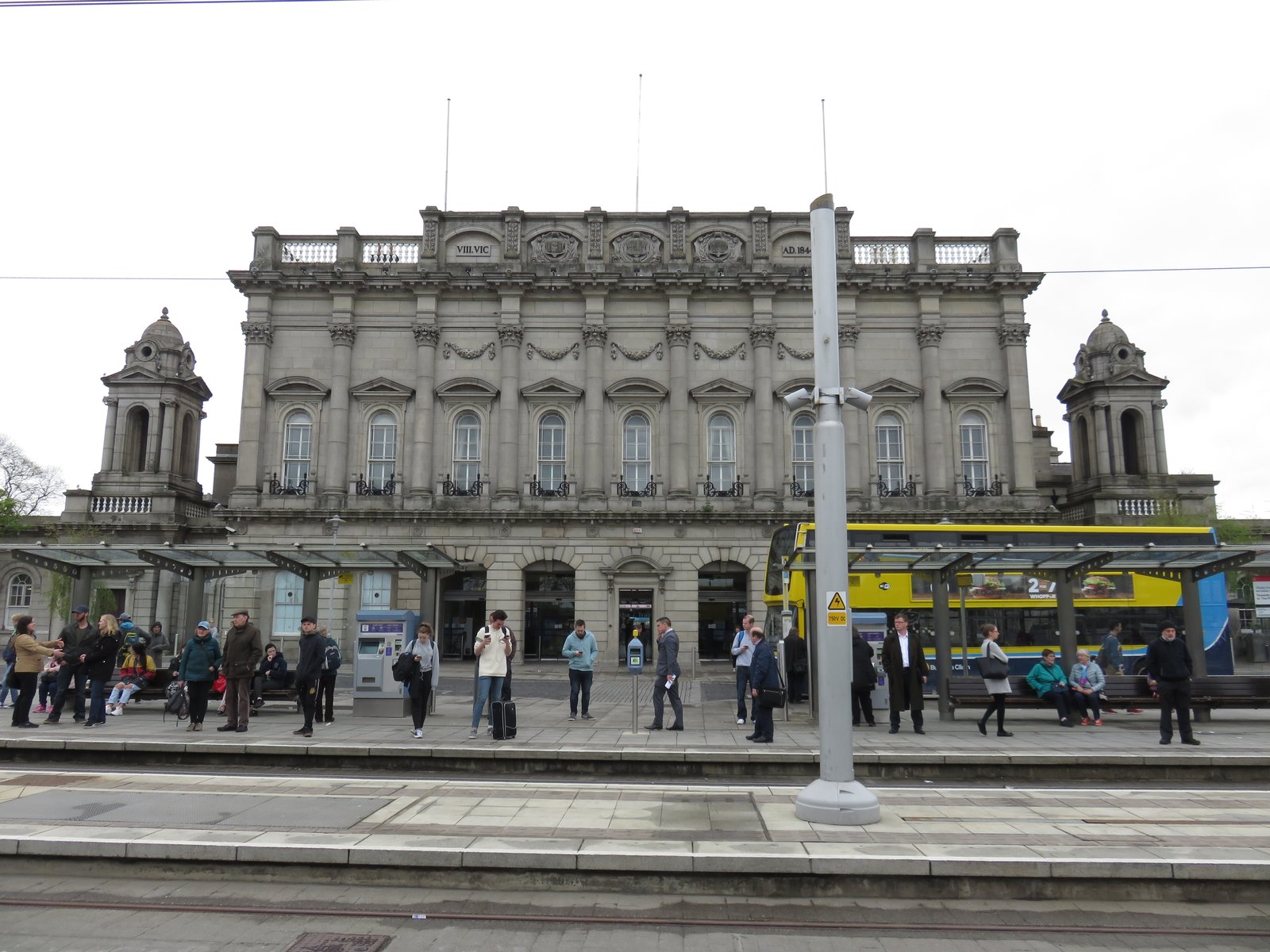 The facade of Heuston Station in Dublin with a Luas tram at the platform