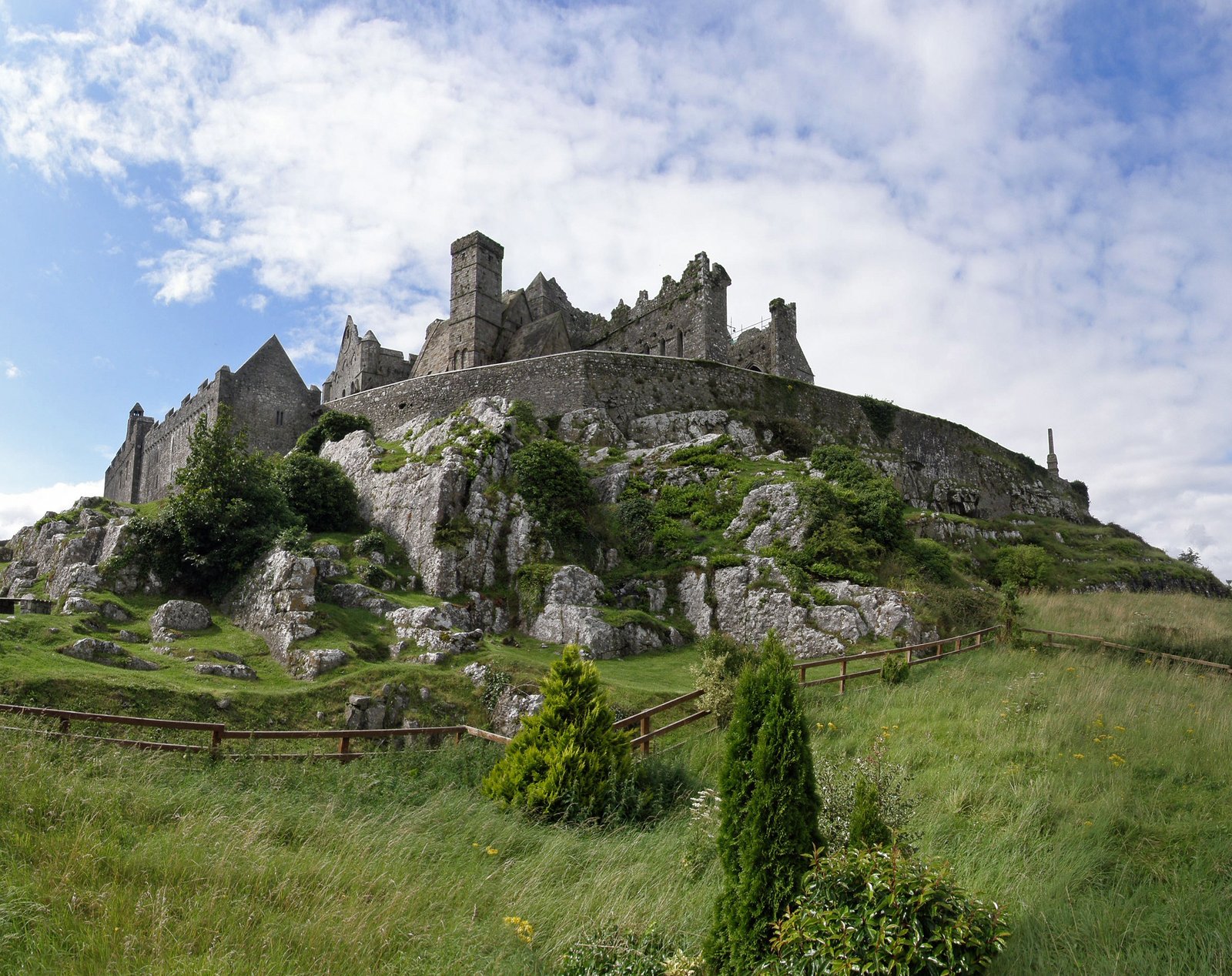 Rock of Cashel medieval ruins on a grassy hill under blue sky in County Tipperary