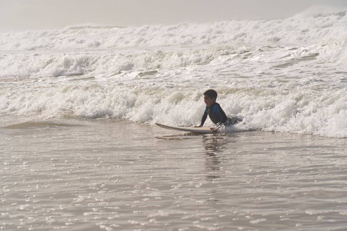 A beginner learning to surf in the whitewater