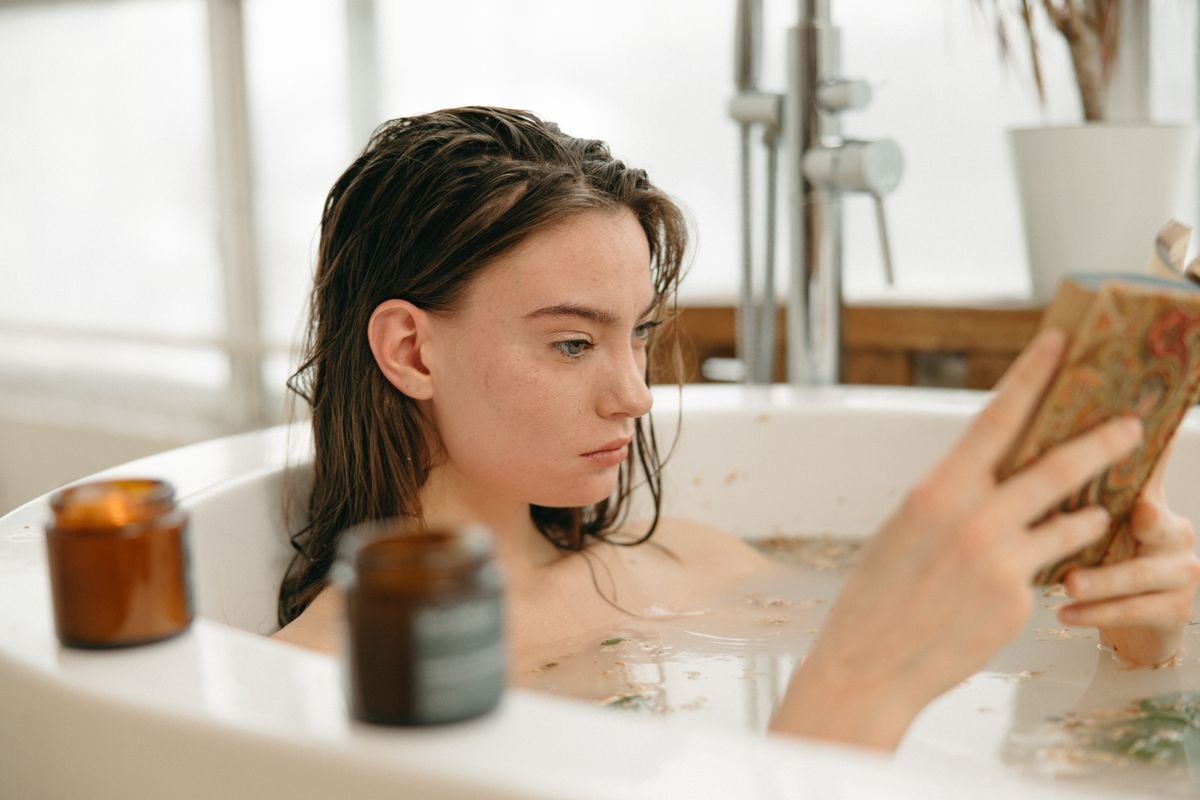 A person relaxing in a bath with natural botanicals in the water