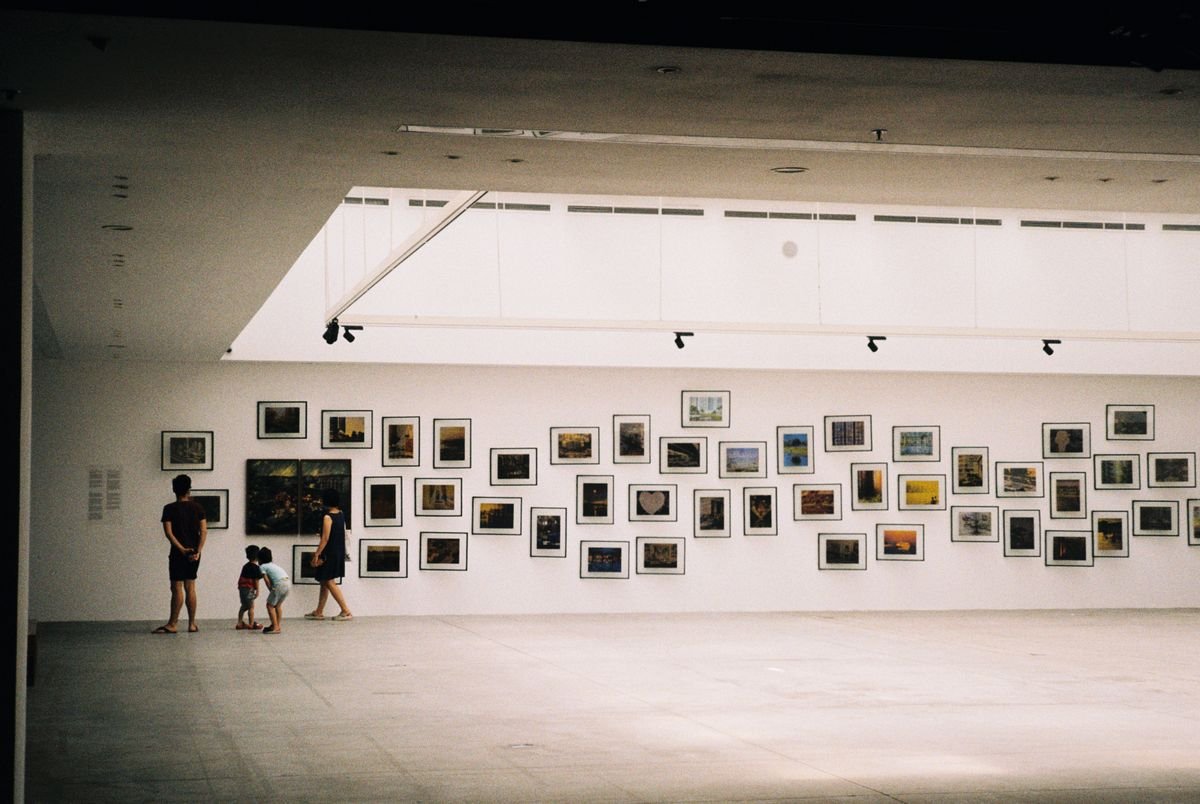 Family with young kids looking at a gallery wall