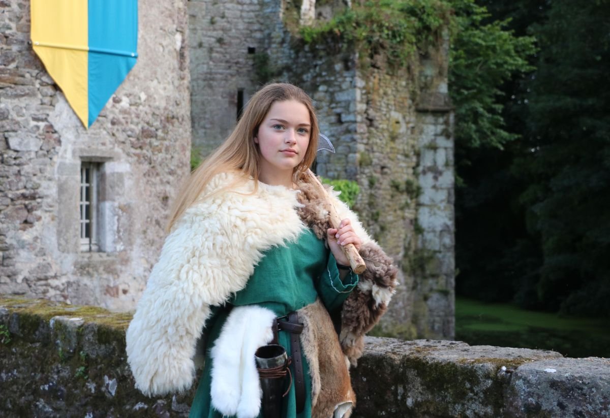 Person in a fur cloak costume at a castle