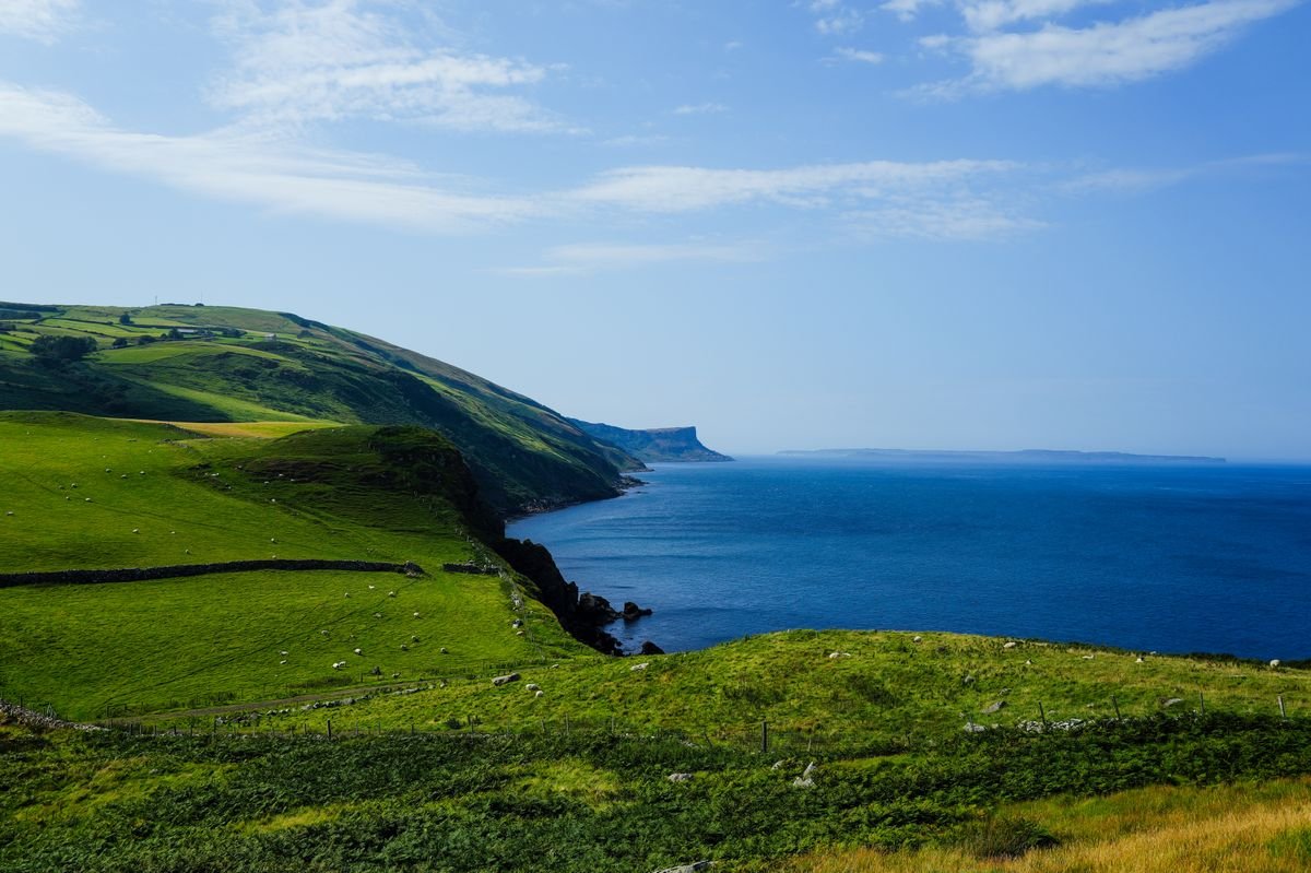 Green Irish coastal hills above the sea in summer