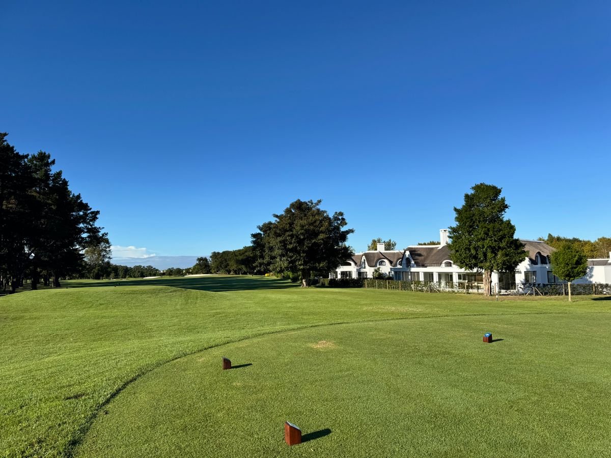 Manicured fairway leading to an upscale golf resort clubhouse