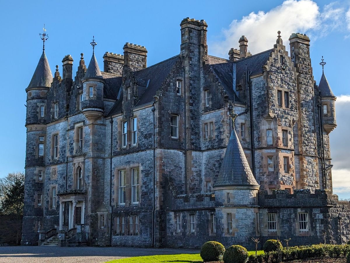 Grey stone Irish castle house under a blue sky