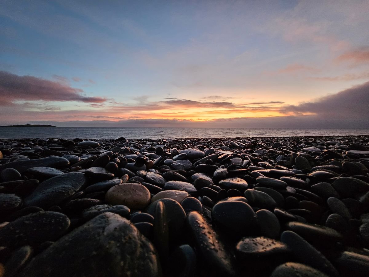 An Irish pebble beach at first light over the sea
