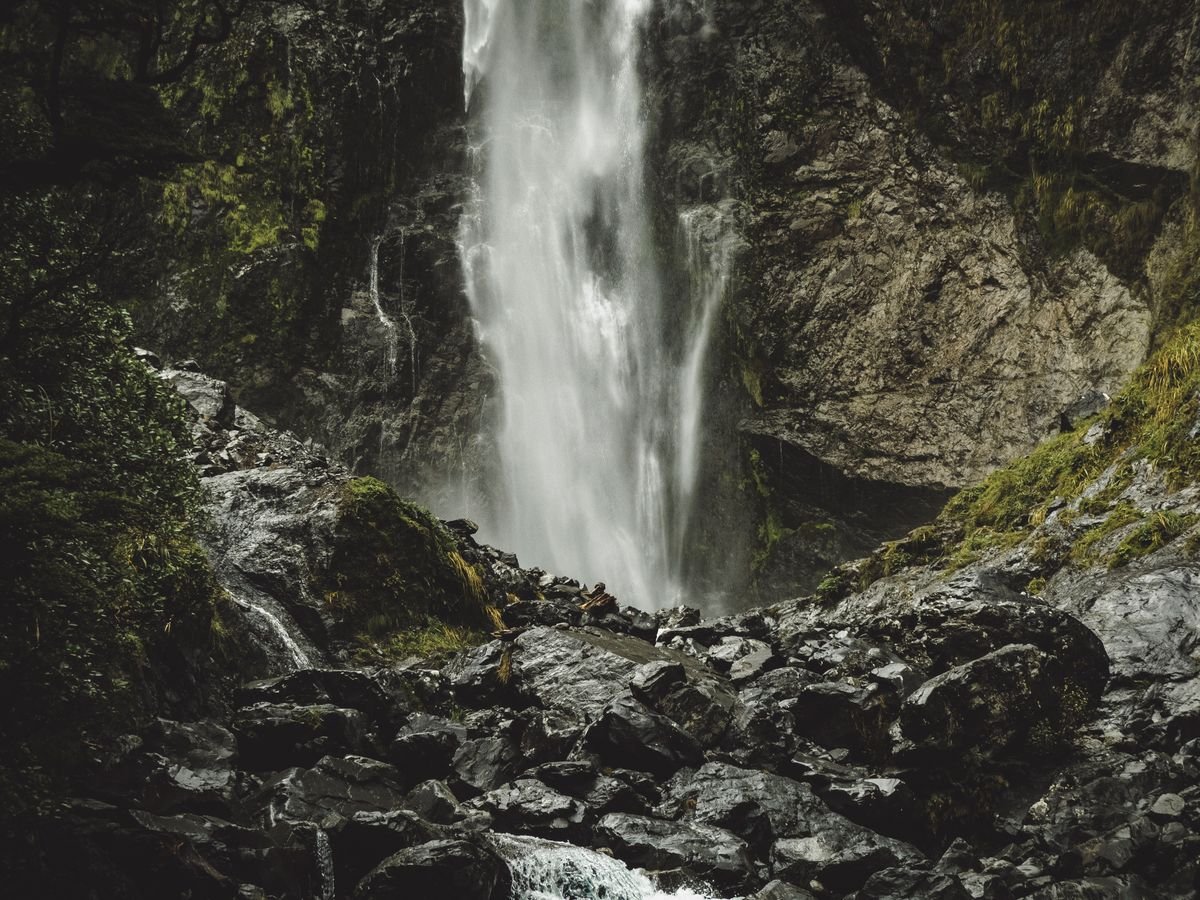Tall waterfall dropping down a dark rock face