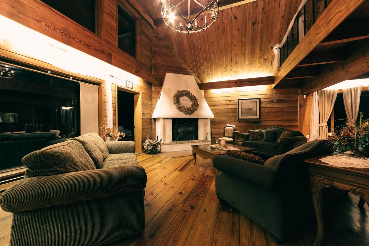A warm cottage living room with a stone fireplace and sofas, like a keeper's quarters stay