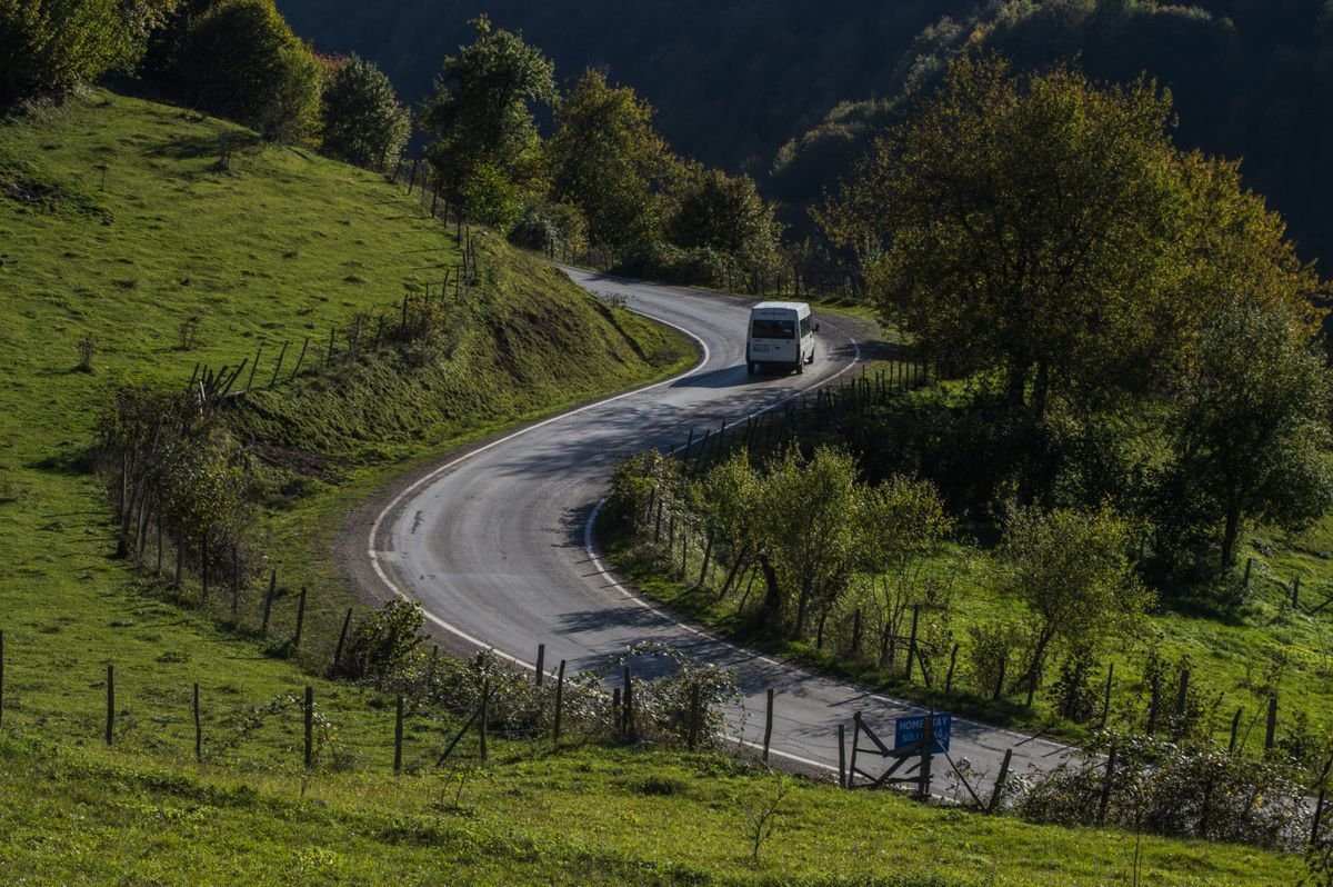 A tour coach on a winding green rural road in Ireland
