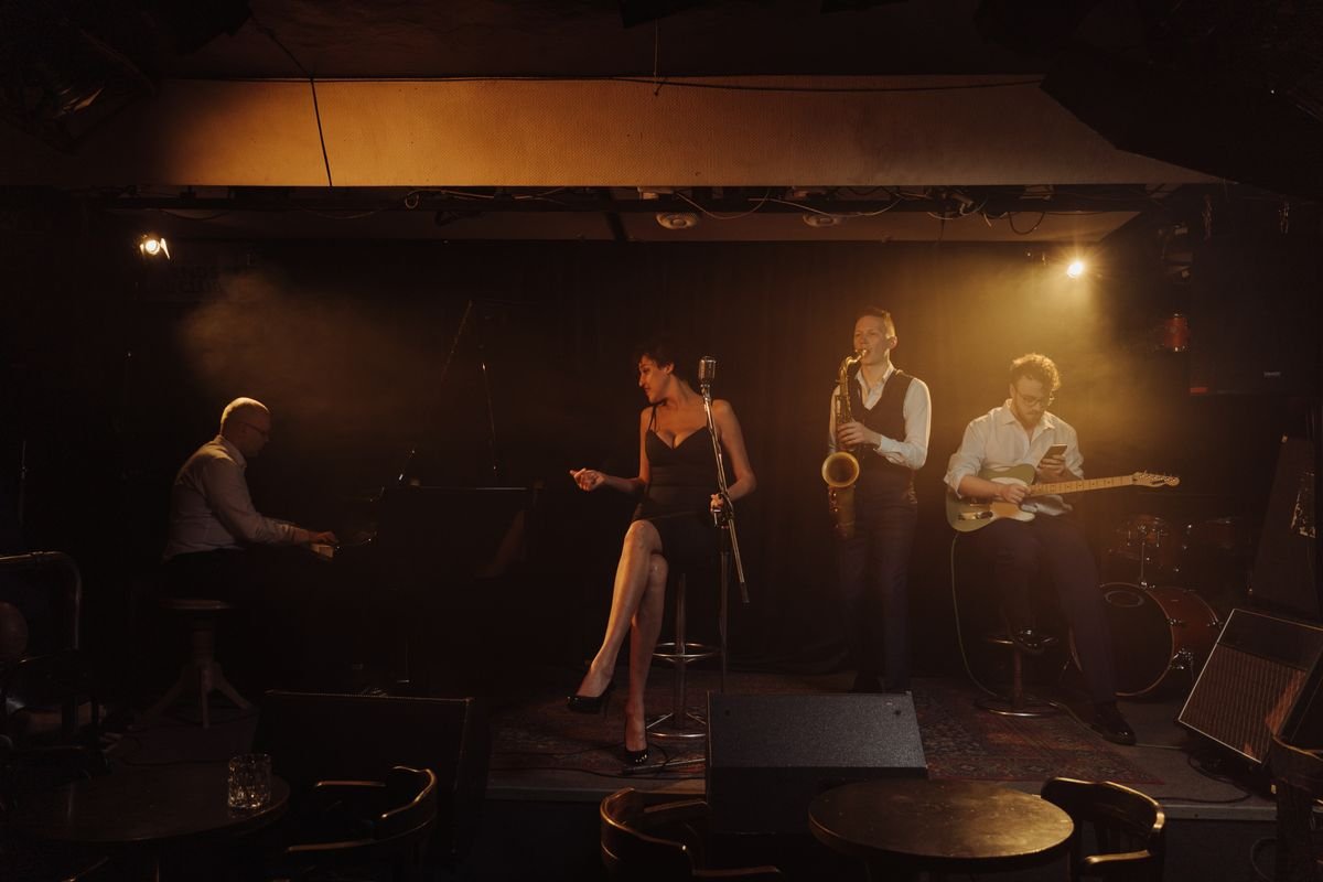 Jazz band with saxophone and piano on a dim club stage