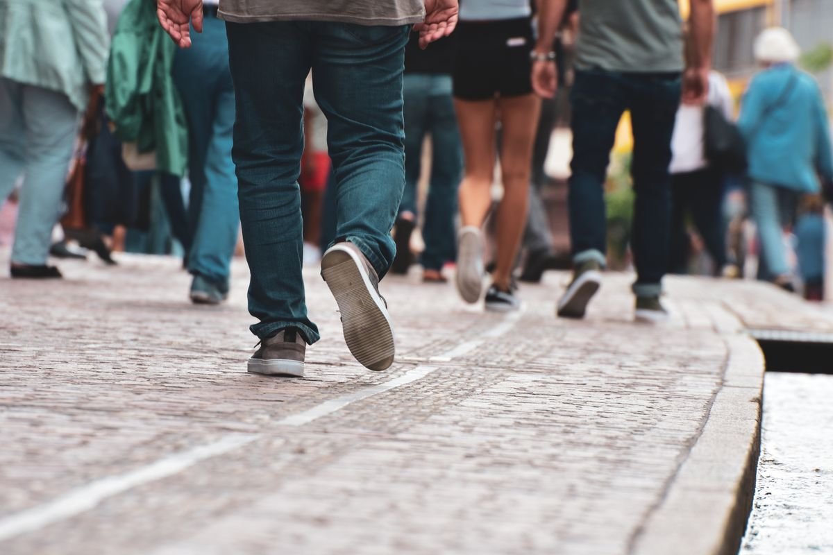 People walking on a cobblestone street, low angle on feet