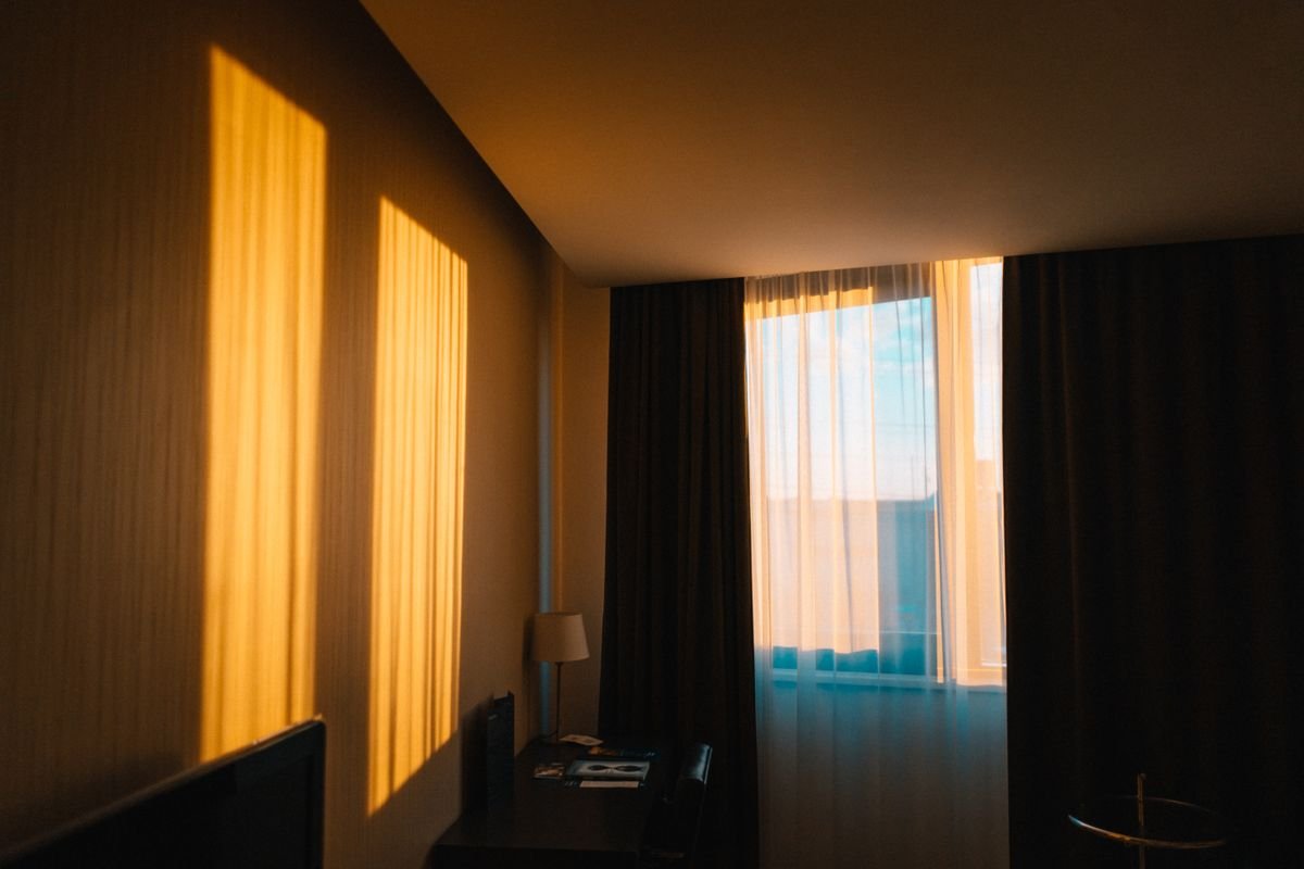Hotel room interior with warm evening light through the window