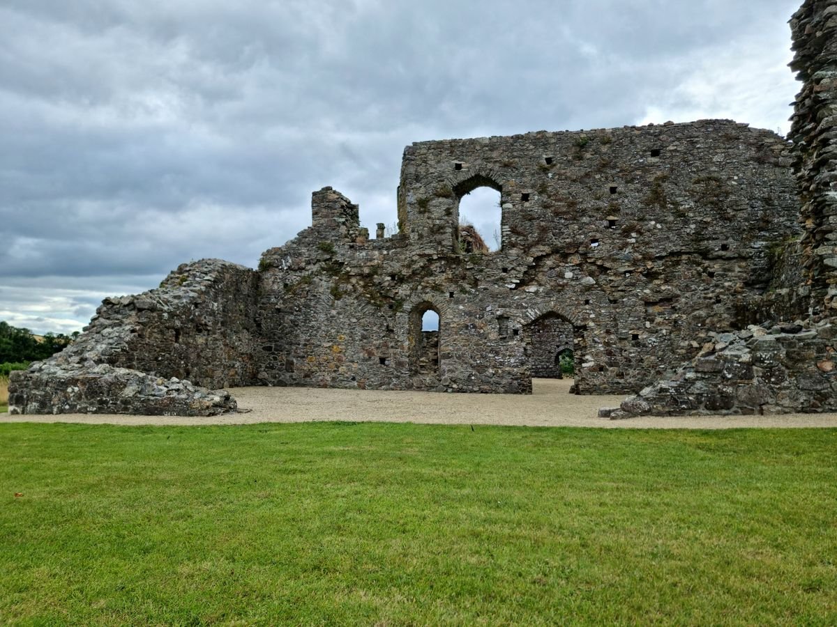 Roofless grey stone ruin under a moody sky