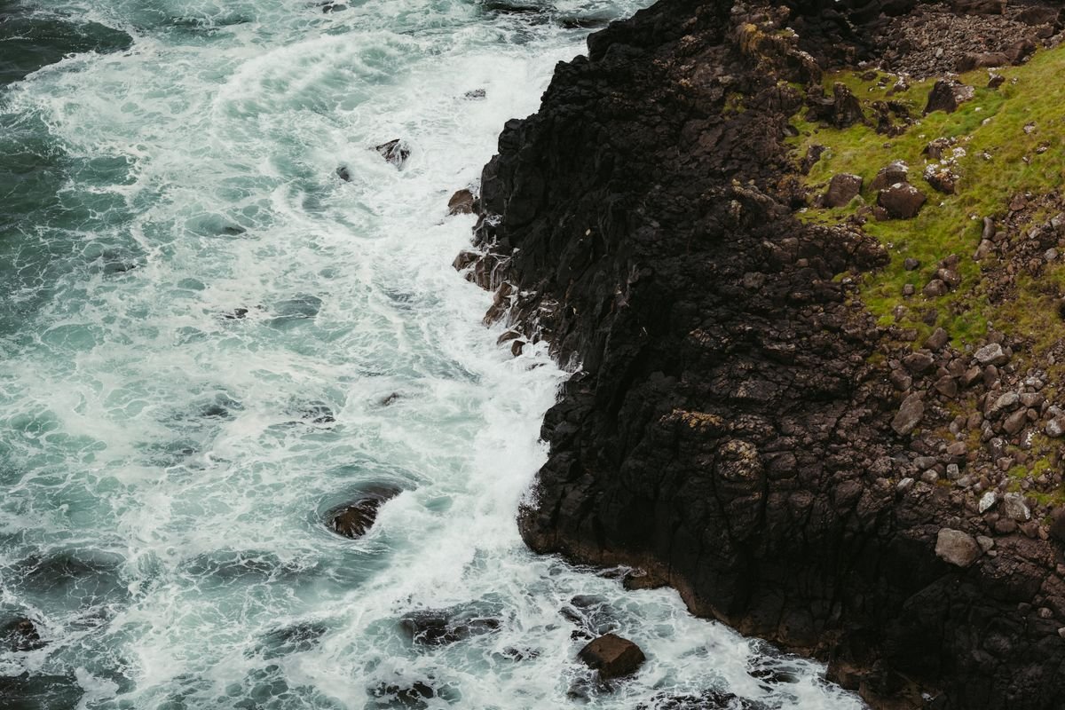 Dramatic Antrim sea cliff meeting crashing Atlantic waves