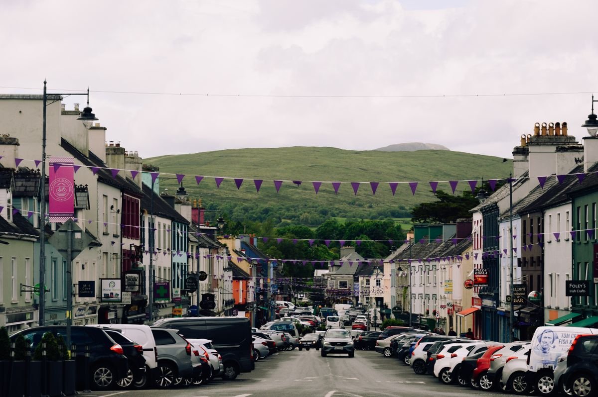 Kenmare's main street lined with painted shopfronts and bunting under the Kerry hills