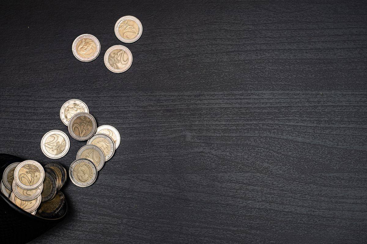 Euro coins spilling from a wallet on a table
