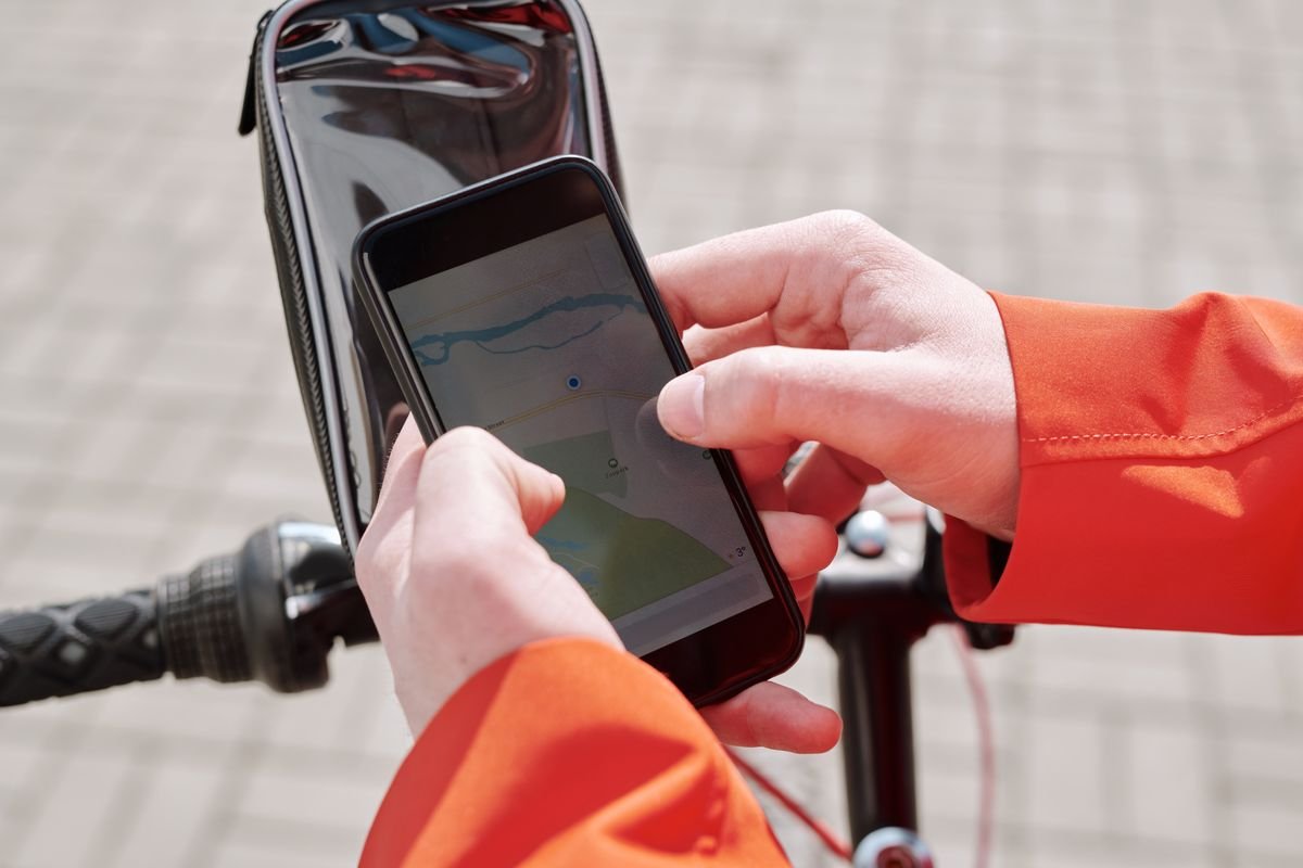 Cyclist checking a route map on a phone on the handlebars