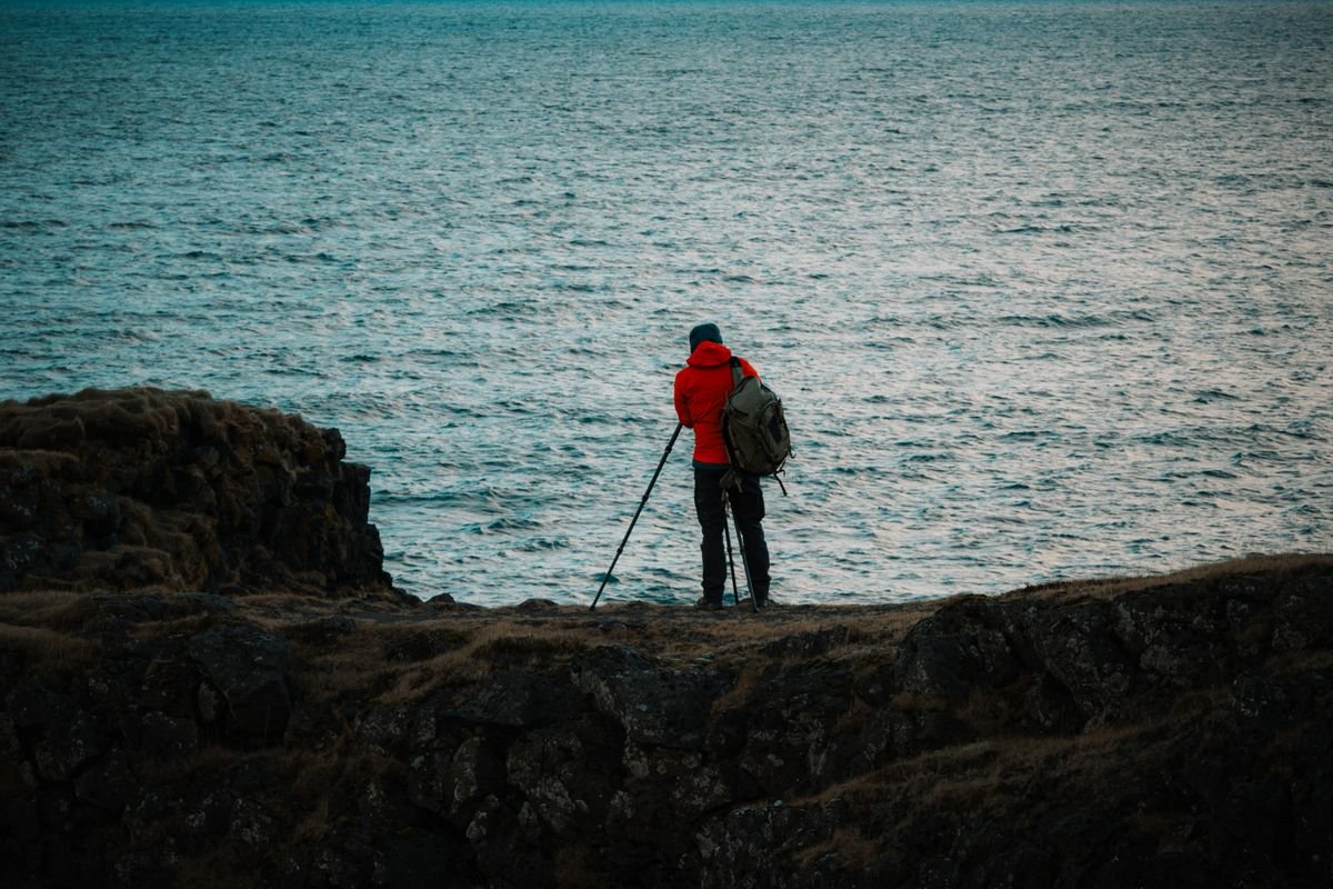 Photographer with a tripod shooting the sea from a rocky Irish coast.
