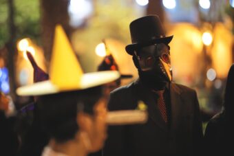 Person in a plague-doctor costume at a night Halloween festival parade