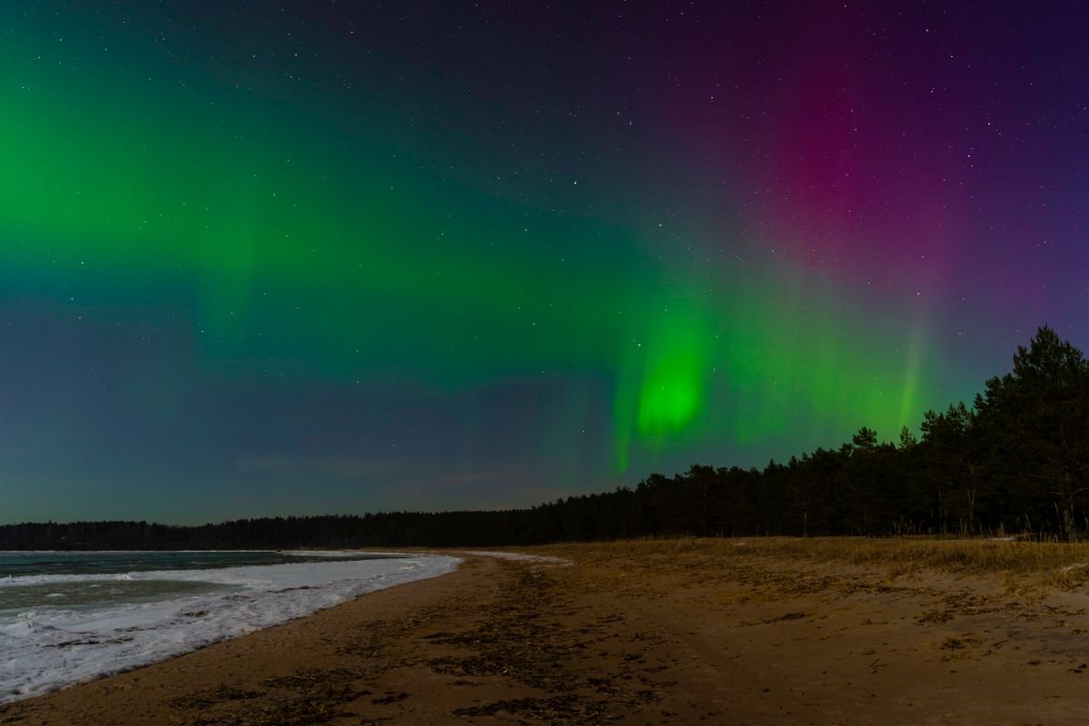 Northern lights over a dark coast in Ireland