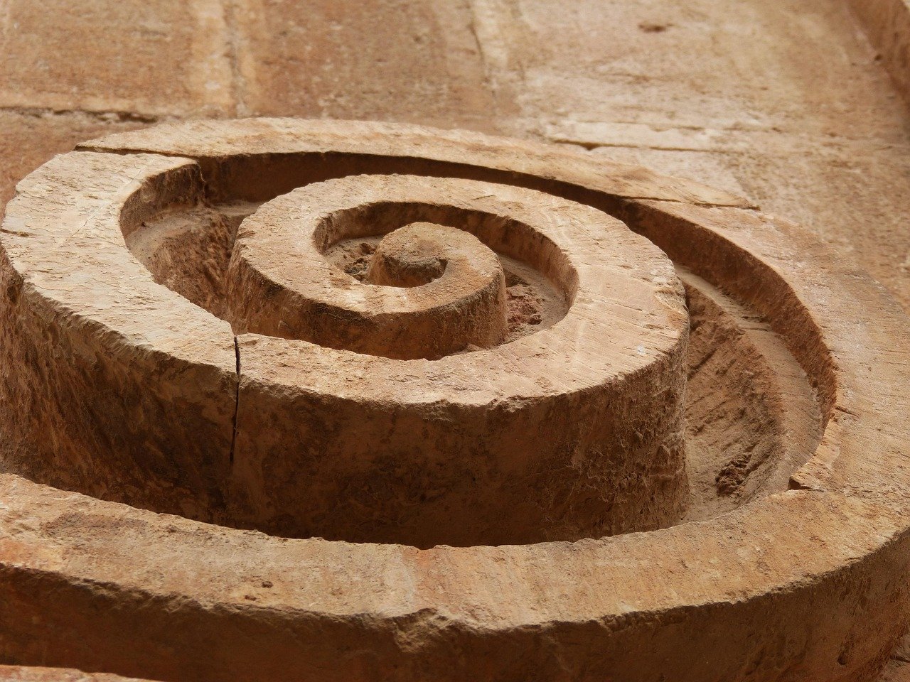 A close-up of a carved megalithic spiral cut into weathered stone